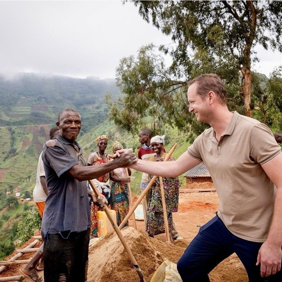 Vrouw met baby in Uganda houdt groenten vast